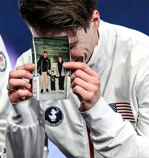 Максим Наумов показывает фотографию себя в трехлетнем возрасте с родителями